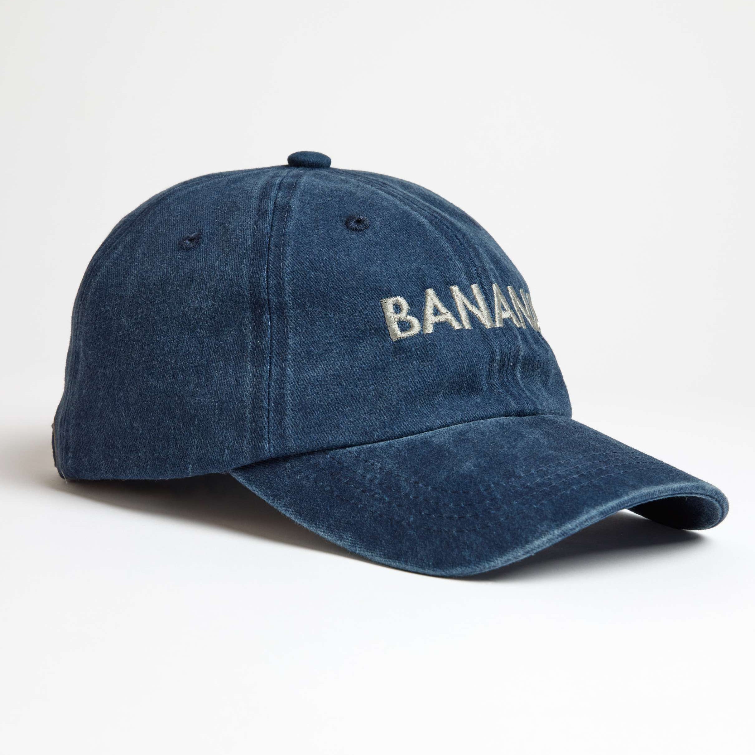 Blue denim cap with 'BANANA' embroidery on a white background