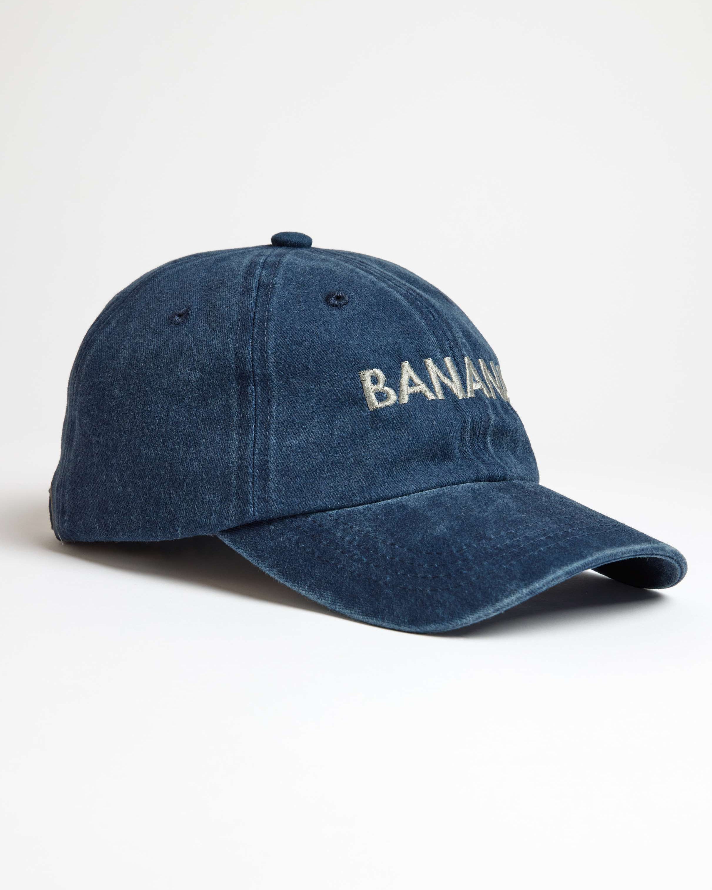 Blue denim cap with 'BANANA' embroidery on a white background