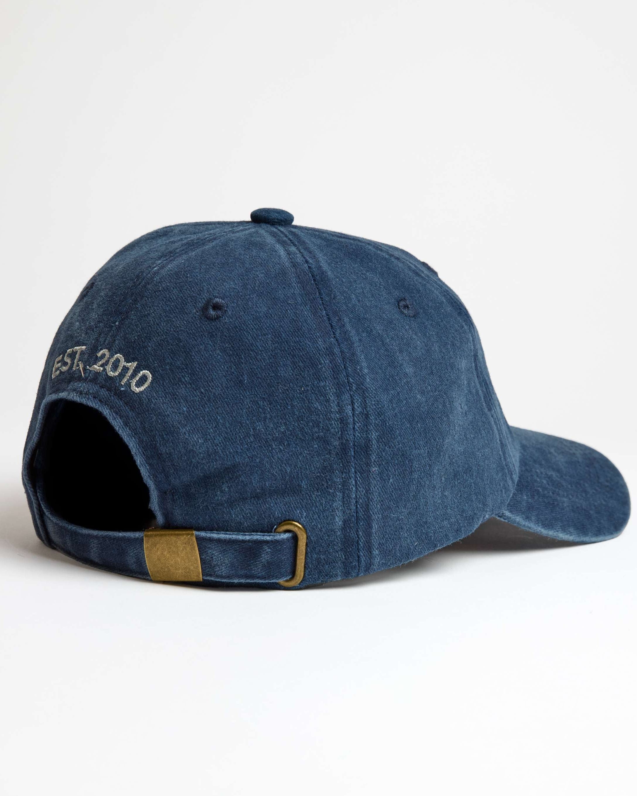 A navy blue denim cap with an adjustable strap and an embroidered logo on the front.